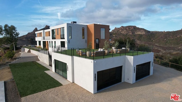 view of front facade featuring a garage, a mountain view, and a balcony