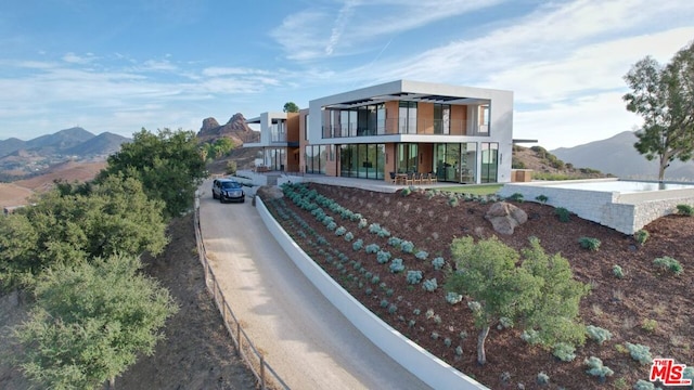 view of front facade featuring a mountain view and a balcony