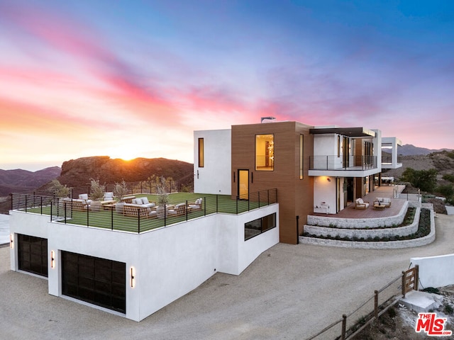 contemporary house with a mountain view, a balcony, and a garage