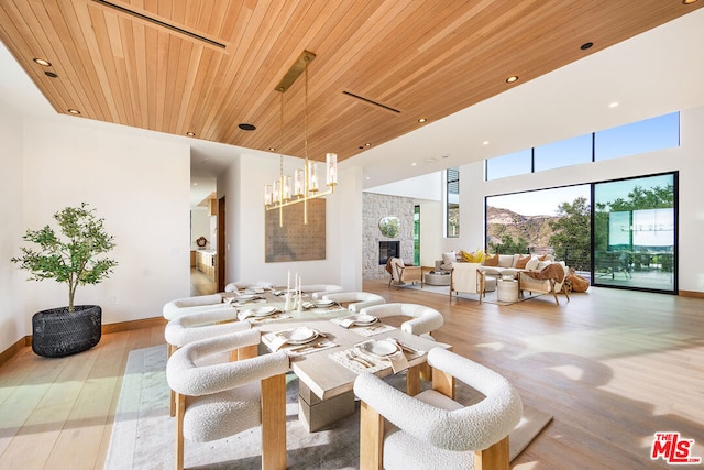 living room with light wood-type flooring, wood ceiling, and a tiled fireplace