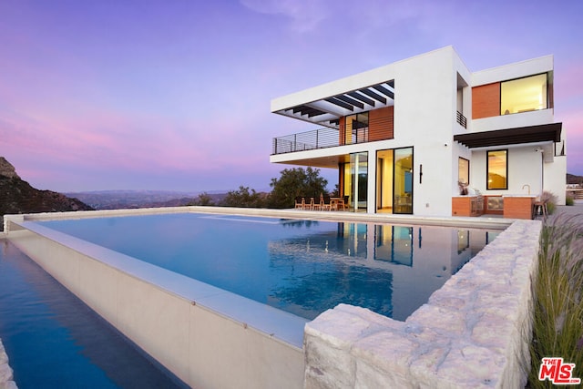 pool at dusk with a patio area