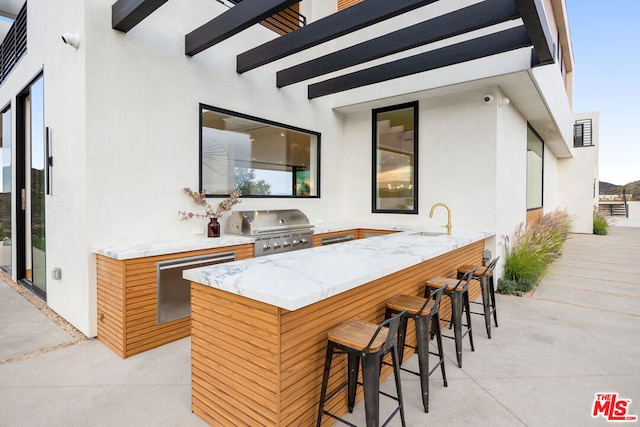 view of patio featuring an outdoor wet bar and area for grilling