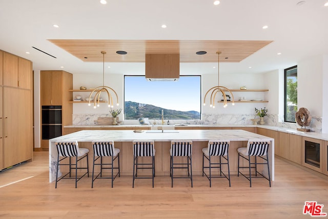 kitchen featuring a kitchen breakfast bar, a mountain view, a spacious island, and decorative light fixtures