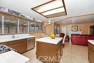 kitchen featuring dishwasher, light tile patterned floors, a center island, and sink