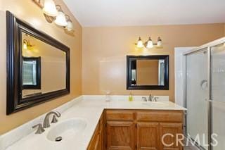 bathroom featuring vanity and a shower with door