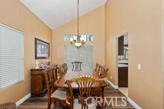 dining area featuring hardwood / wood-style flooring, lofted ceiling, and a notable chandelier