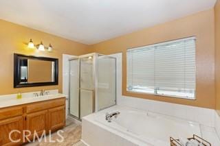 bathroom with vanity and shower with separate bathtub