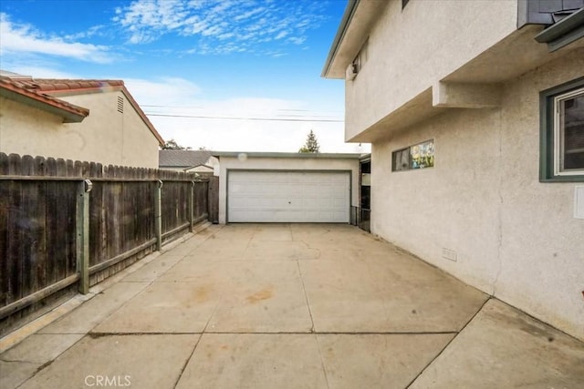 view of property exterior featuring stucco siding, crawl space, fence, a garage, and an outdoor structure