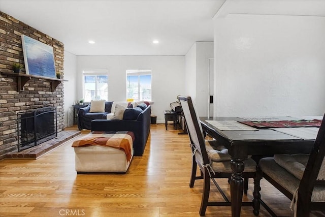 dining area featuring light wood-style floors, a fireplace, and recessed lighting