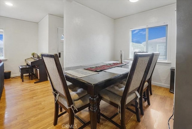 dining space featuring light wood finished floors and baseboards