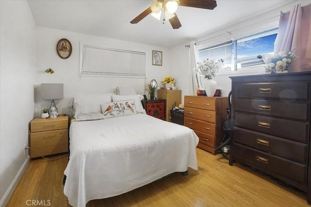 bedroom featuring a ceiling fan, baseboards, and light wood finished floors