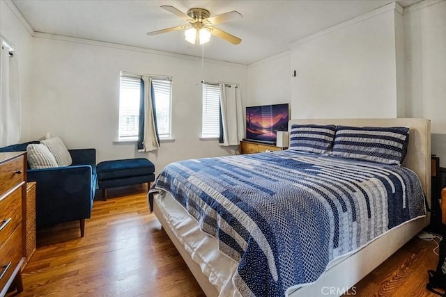 bedroom with wood finished floors, a ceiling fan, and crown molding