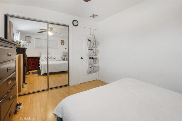 bedroom with visible vents, light wood-style flooring, and a ceiling fan