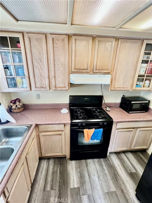 kitchen featuring range hood, light countertops, light wood-style flooring, light brown cabinetry, and gas stove