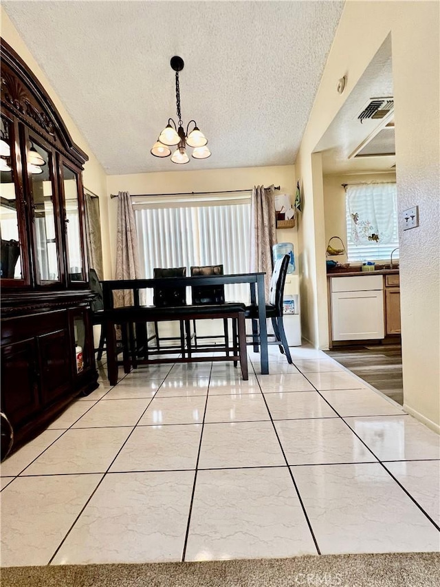 dining space with visible vents, vaulted ceiling, a textured ceiling, and an inviting chandelier