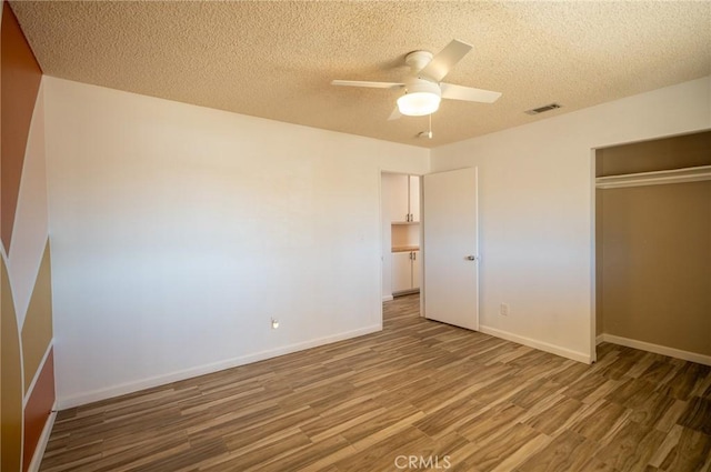 58168 Canterbury St, Yucca Valley, CA 92284 - unfurnished bedroom featuring wood finished floors, a closet, a textured ceiling, and a ceiling fan