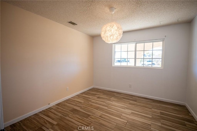 58168 Canterbury St, Yucca Valley, CA 92284 - unfurnished room featuring wood finished floors, a textured ceiling, and a chandelier