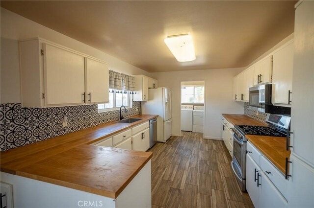58168 Canterbury St, Yucca Valley, CA 92284 - kitchen featuring stainless steel appliances, washer and dryer, butcher block countertops, and decorative backsplash