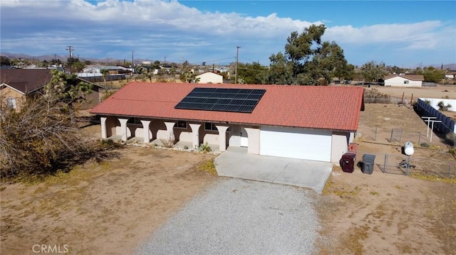 view of front facade with solar panels and a garage