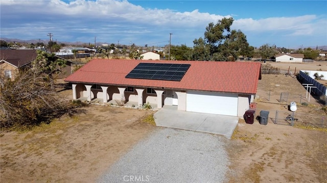 58168 Canterbury St, Yucca Valley, CA 92284 - view of front of property with driveway, roof mounted solar panels, stucco siding, and an attached garage