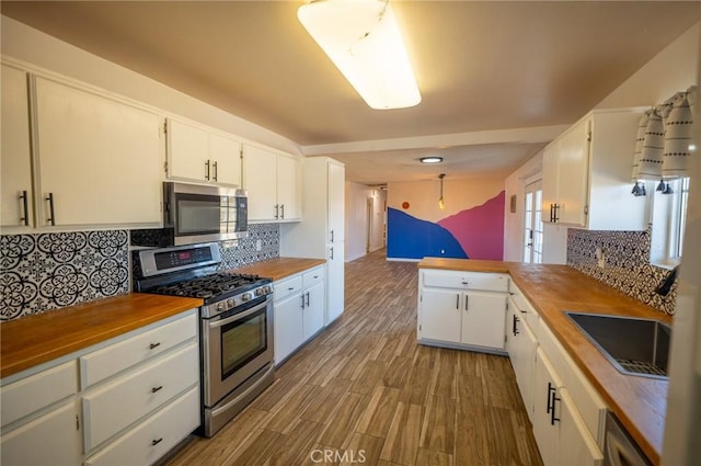 58168 Canterbury St, Yucca Valley, CA 92284 - kitchen with stainless steel appliances, wood counters, wood finished floors, and tasteful backsplash
