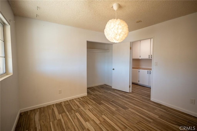 58168 Canterbury St, Yucca Valley, CA 92284 - unfurnished bedroom featuring wood finished floors, a closet, a chandelier, and a textured ceiling