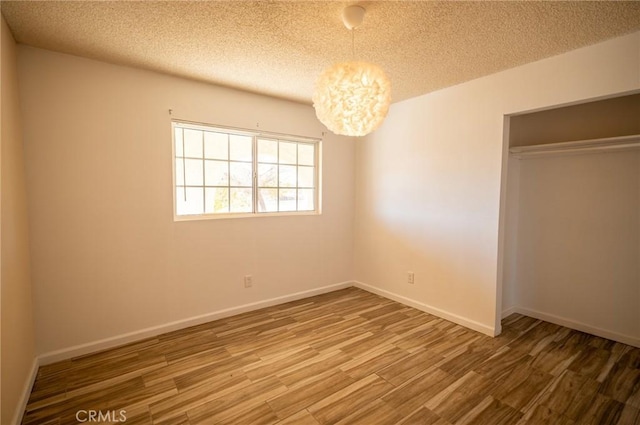 58168 Canterbury St, Yucca Valley, CA 92284 - unfurnished bedroom with wood finished floors, a chandelier, a textured ceiling, and a closet