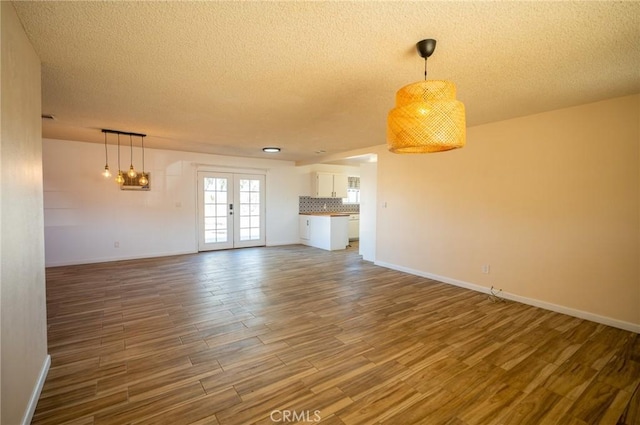 58168 Canterbury St, Yucca Valley, CA 92284 - unfurnished living room with a textured ceiling, wood finished floors, and french doors