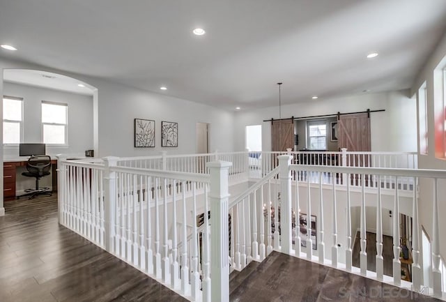 hallway with hardwood / wood-style floors and a barn door