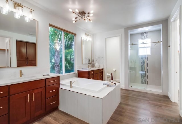 full bathroom featuring a notable chandelier, separate shower and tub, toilet, vanity, and hardwood / wood-style flooring