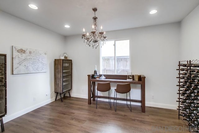 dining room with dark hardwood / wood-style floors and a notable chandelier