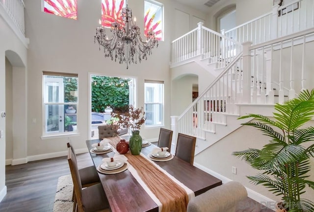 dining area with dark hardwood / wood-style flooring, a chandelier, and a high ceiling