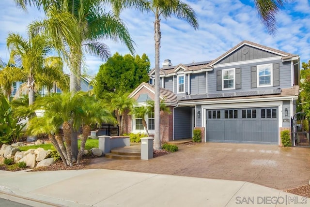 view of front of property with solar panels and a garage