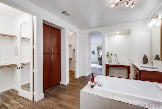 bathroom with a bathtub, hardwood / wood-style floors, and vanity