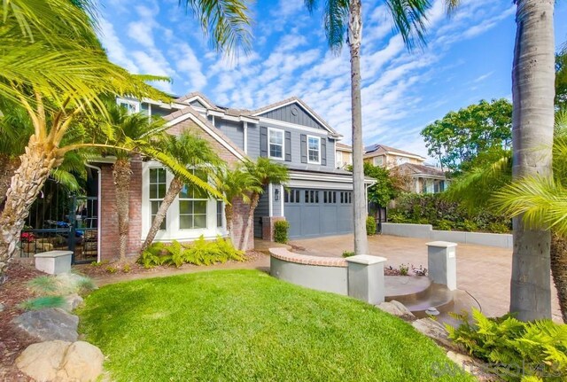 view of front of home with a garage and a front lawn