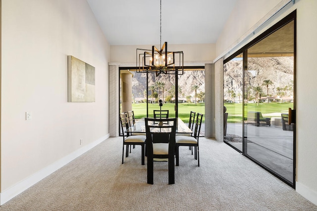 dining area featuring a chandelier, carpet floors, and lofted ceiling