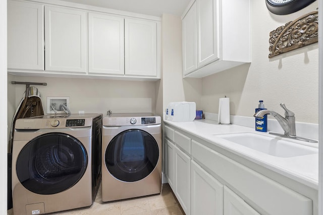 laundry area with washing machine and clothes dryer, sink, and cabinets