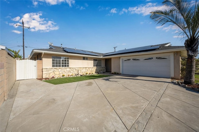 ranch-style house with solar panels and a garage