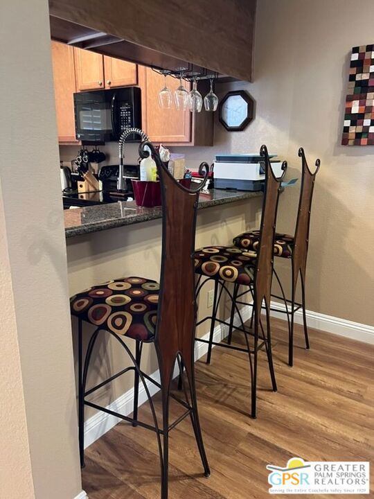 interior space with stainless steel electric stove, dark stone counters, and light hardwood / wood-style flooring