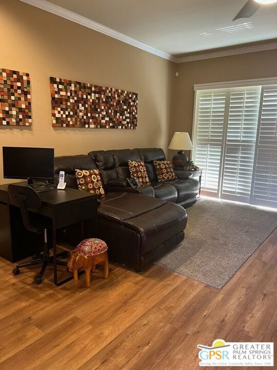 living room with wood-type flooring and ornamental molding