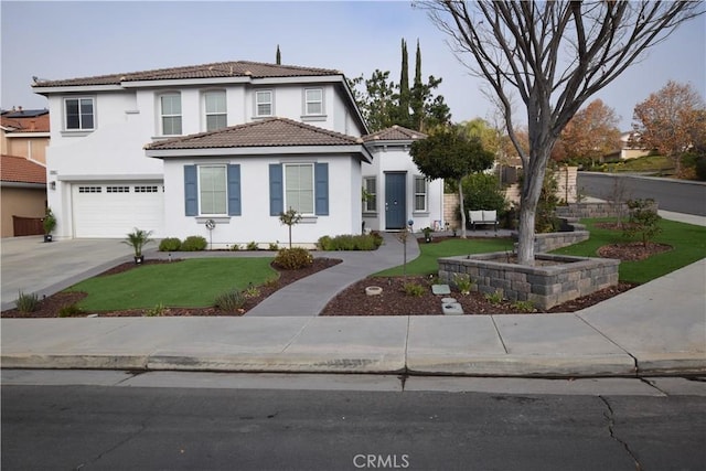 mediterranean / spanish-style house featuring a garage and a front yard