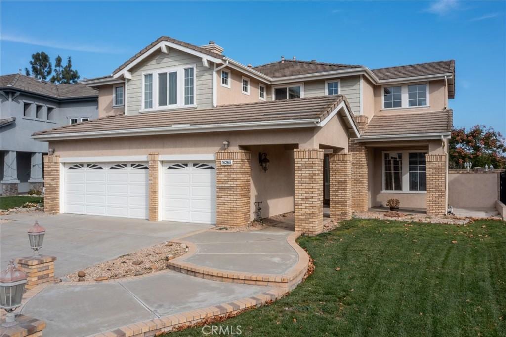 front of property featuring a front lawn and a garage