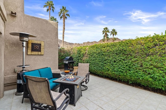 view of patio with a mountain view, a fire pit, and a grill