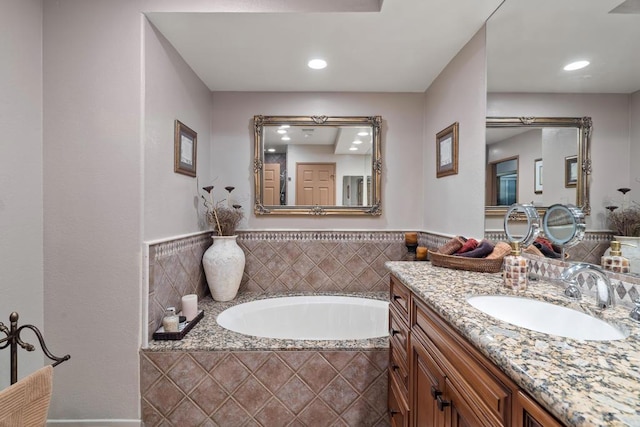 bathroom with vanity and tiled tub