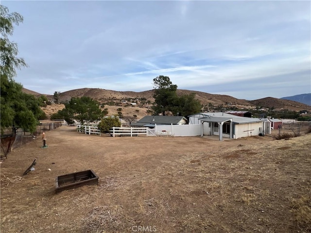 view of yard featuring a mountain view, a rural view, and an outdoor structure