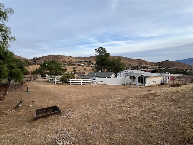 view of yard with a mountain view, a rural view, and an outbuilding