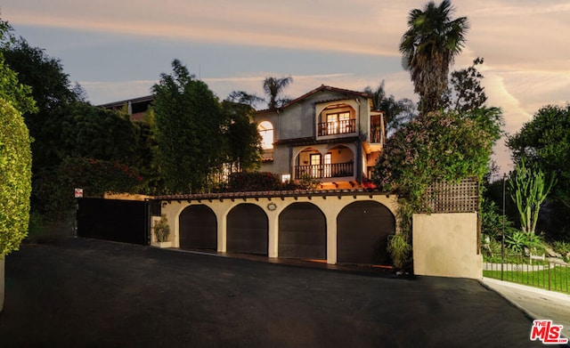 mediterranean / spanish-style house featuring a balcony and a garage