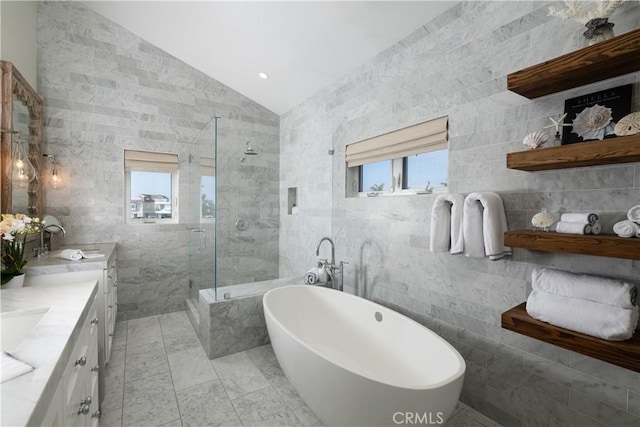 bathroom with vanity, vaulted ceiling, and tile walls