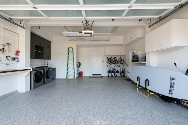 garage featuring washer and clothes dryer, sink, and a garage door opener