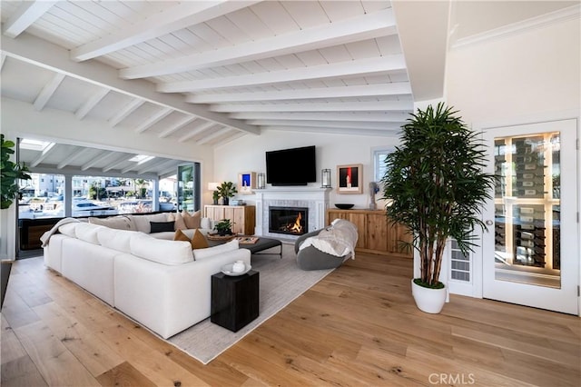 living room with vaulted ceiling with beams and light hardwood / wood-style flooring